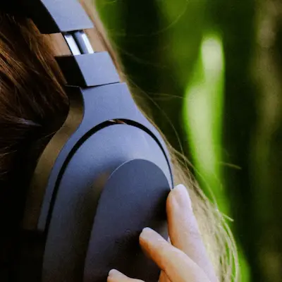 A serene woman with headphones on, eyes closed, in a calm state.